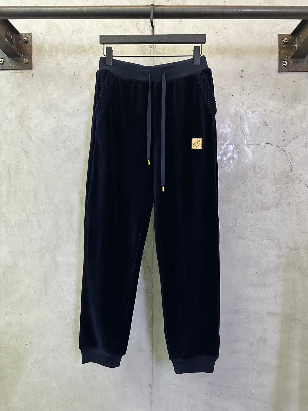 Navy drawstring pants with elastic waistband and gold-tipped cords