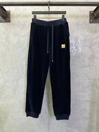 Navy drawstring pants with elastic waistband and gold-tipped cords