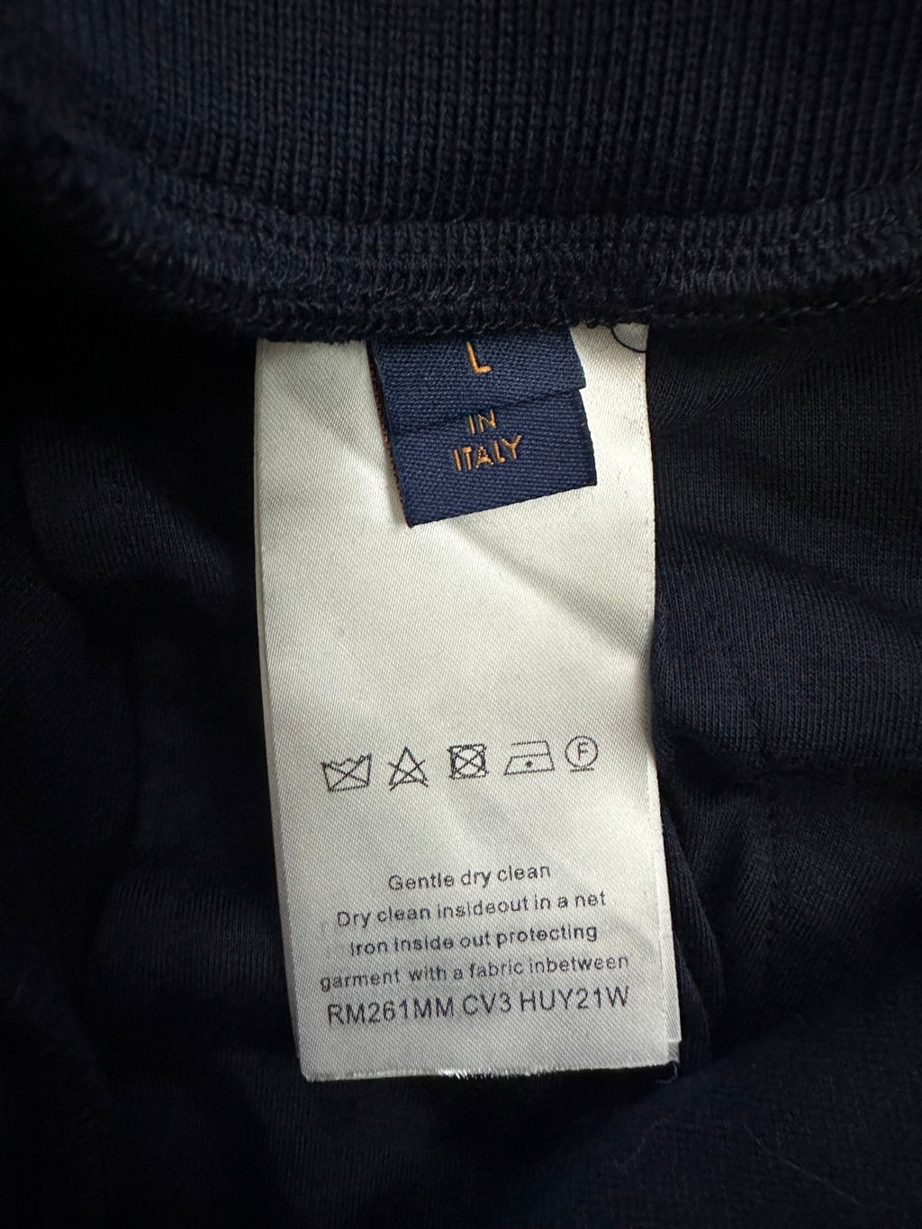 Navy pants care label with 'L in Italy' and cleaning instructions