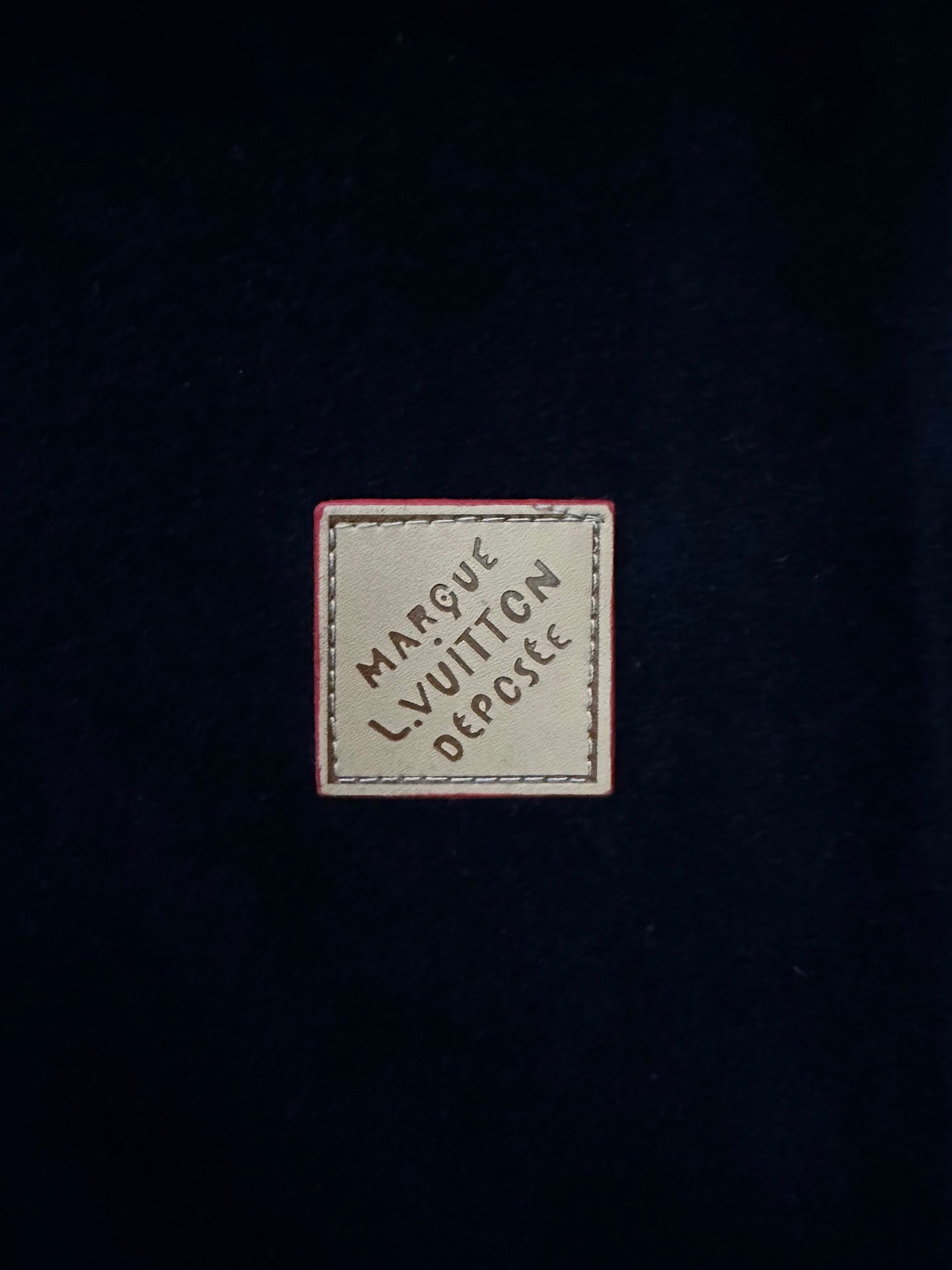 Rectangular logo patch on navy pants fabric