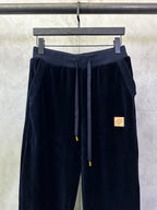 Navy pants with textured side panels, drawstring ties, and logo patch
