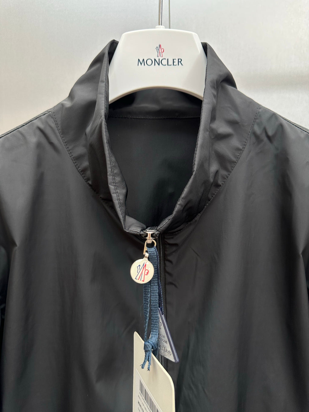 Moncler long jacket collar close-up with front zipper and Moncler logo patch