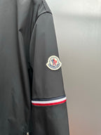 Moncler long jacket sleeve with circular logo patch and red-white-blue stripe band