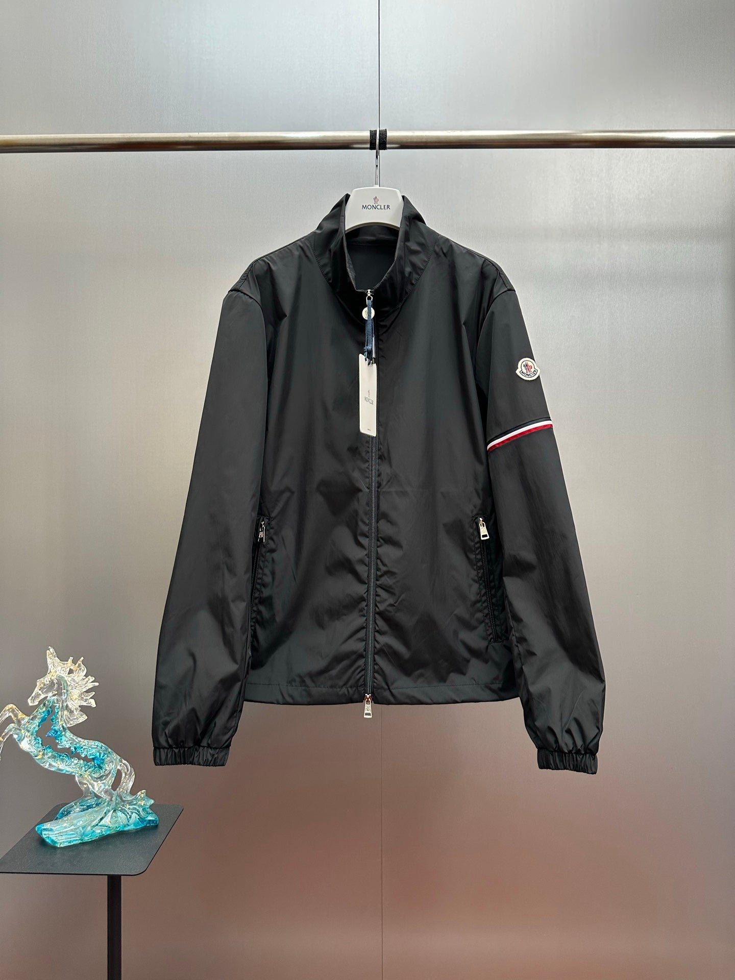 Moncler long jacket with front zipper, stand collar, and sleeve logo patch