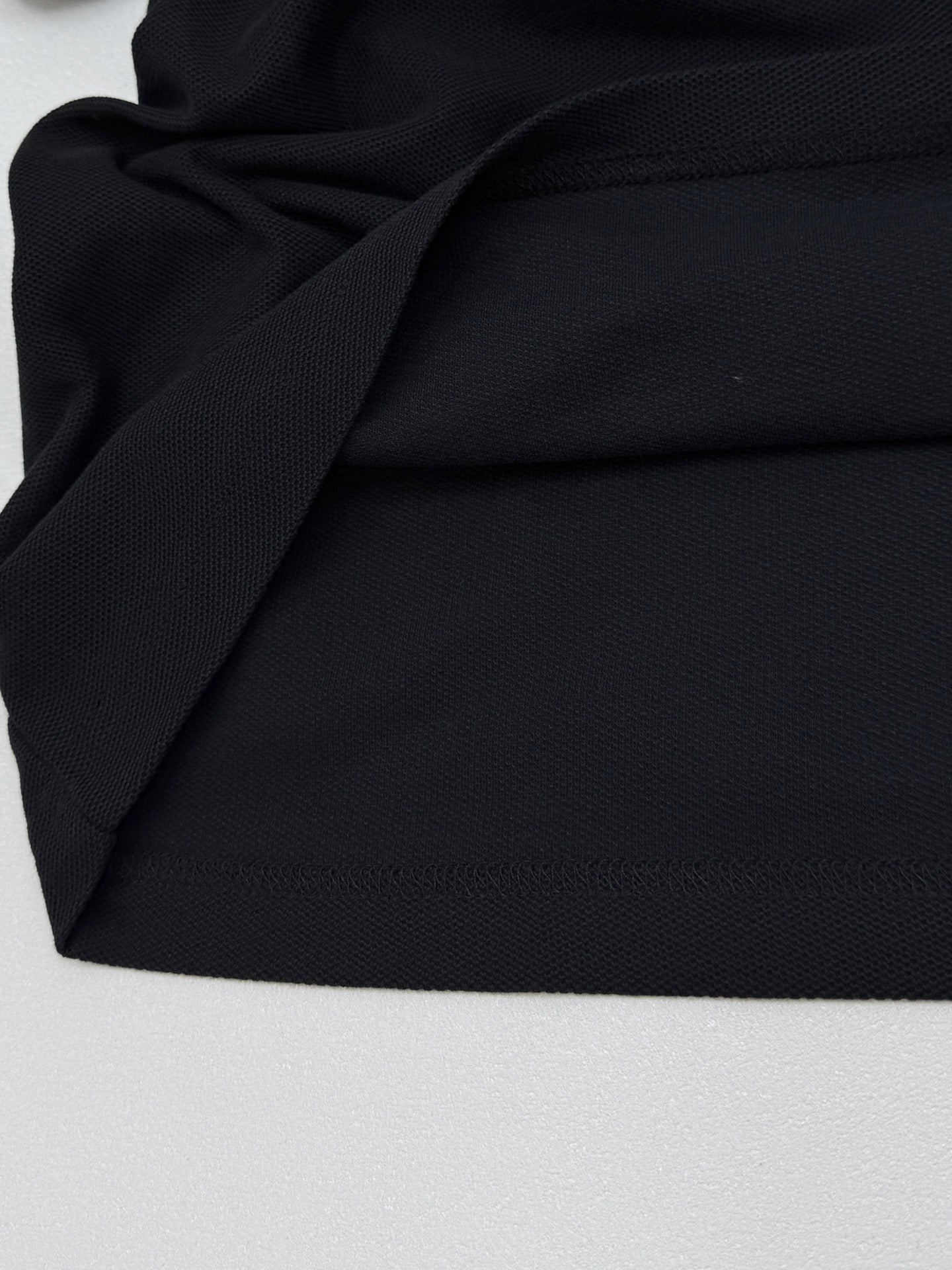 Moncler polo shirt fabric close-up with textured black knit
