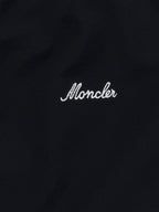 Moncler logo script on black polo shirt fabric