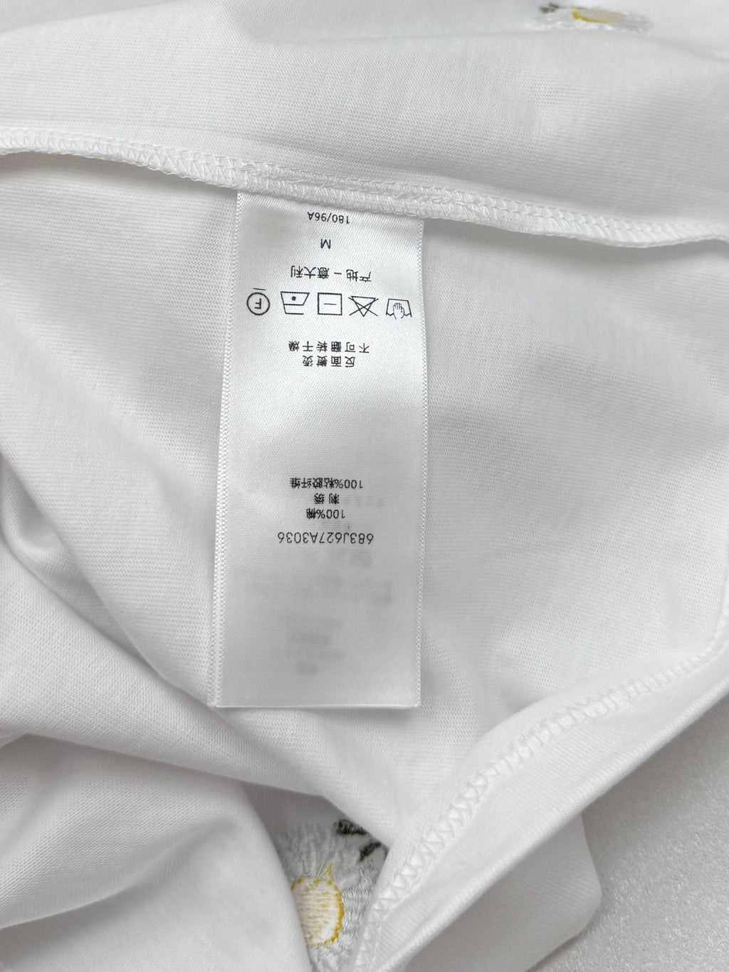 Inside collar seam with size and care tag on white T-shirt
