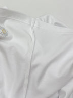 Side seam and embroidered daisy near hem on white T-shirt
