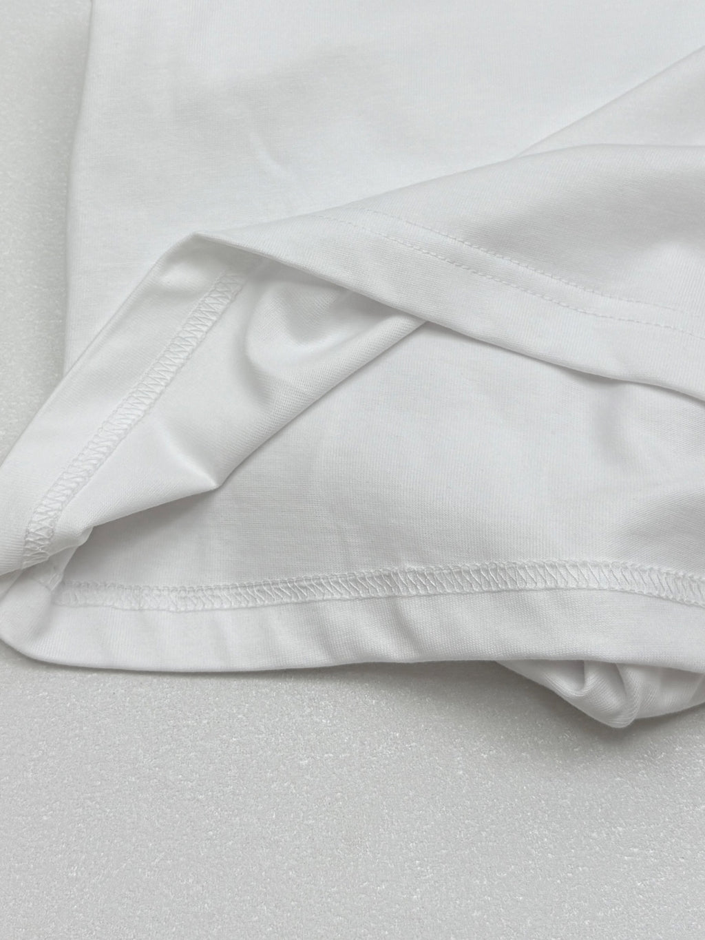White T-shirt fabric drape with stitched hem and sleeve seam