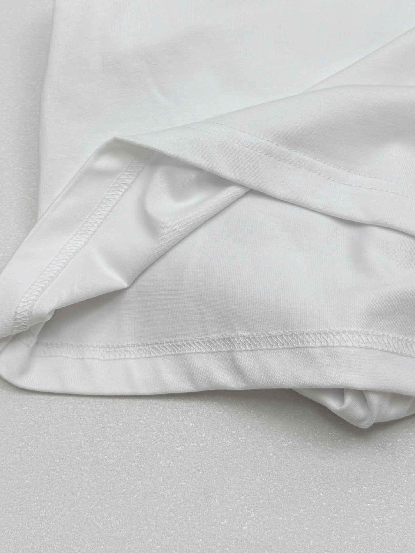 White T-shirt fabric drape with stitched hem and sleeve seam