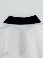 Moncler polo neckline with black collar band on white fabric