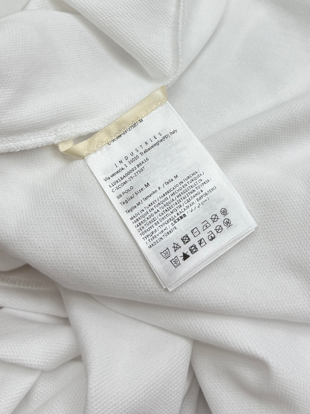 Moncler size and care label on white polo shirt interior