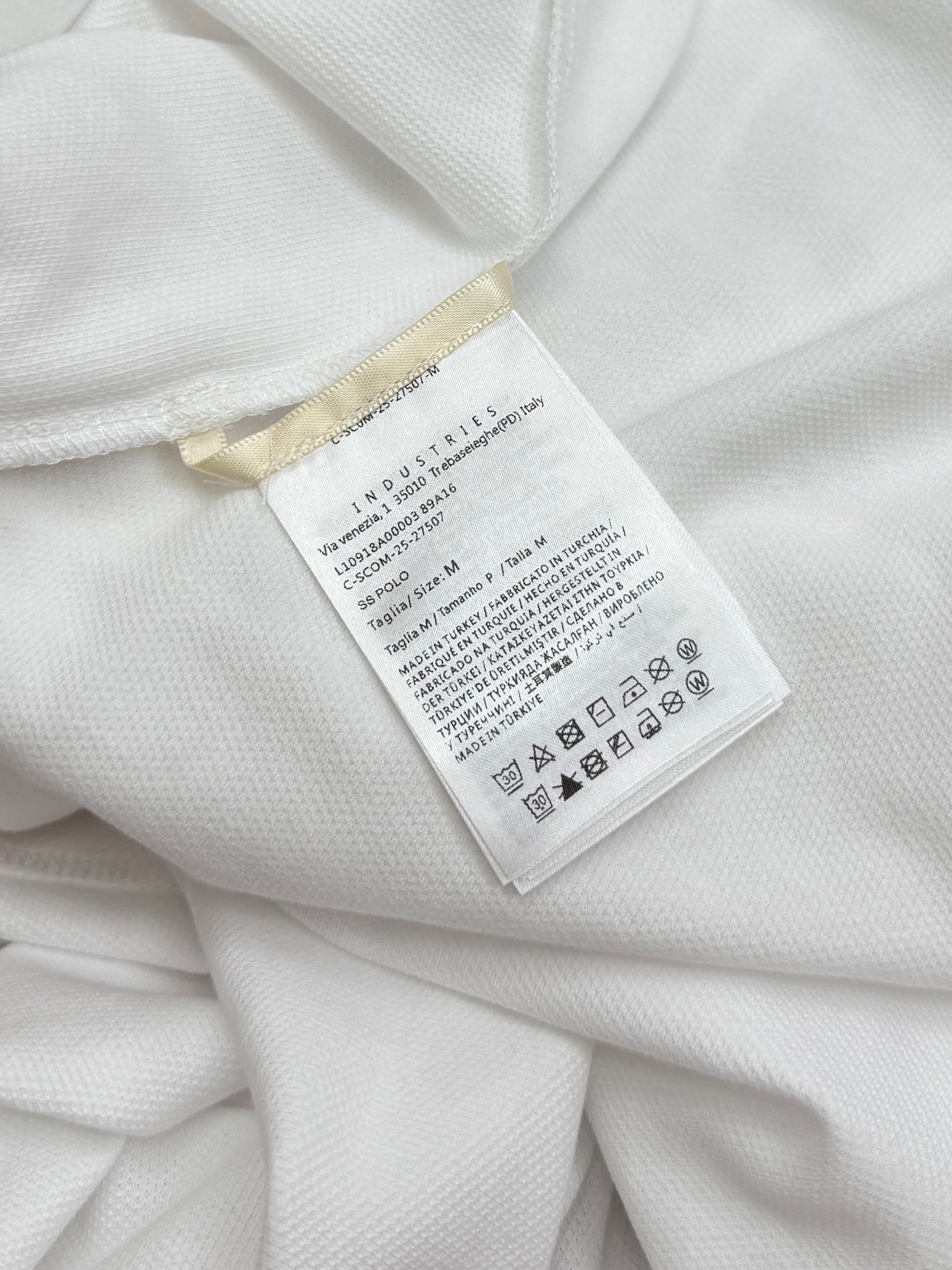 Moncler size and care label on white polo shirt interior