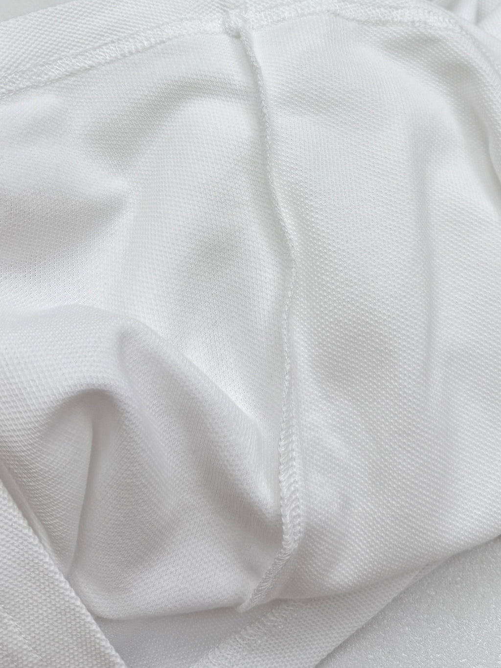 Moncler white polo shirt fabric texture close-up