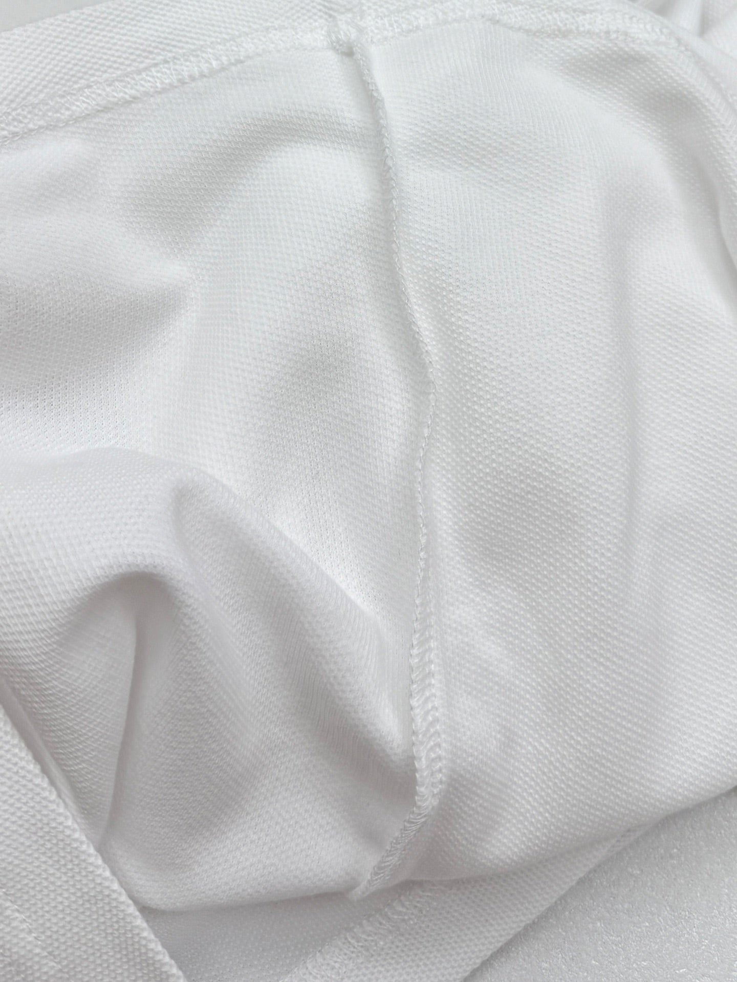 Moncler white polo shirt fabric texture close-up