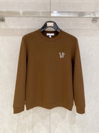 Brown crewneck sweatshirt with small V logo on left chest