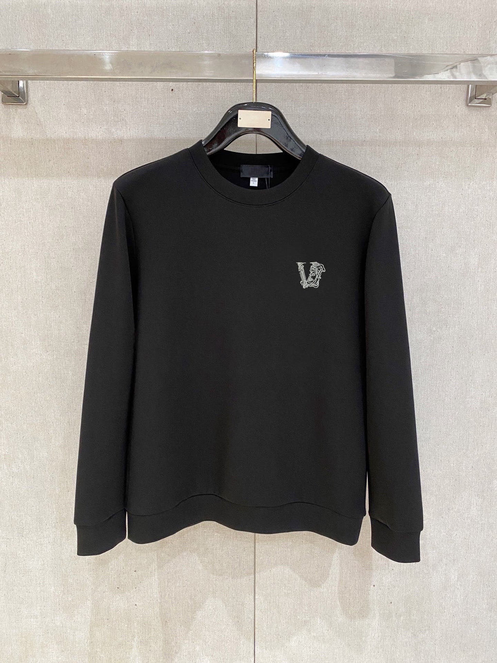 Black crewneck sweatshirt with small V logo on left chest