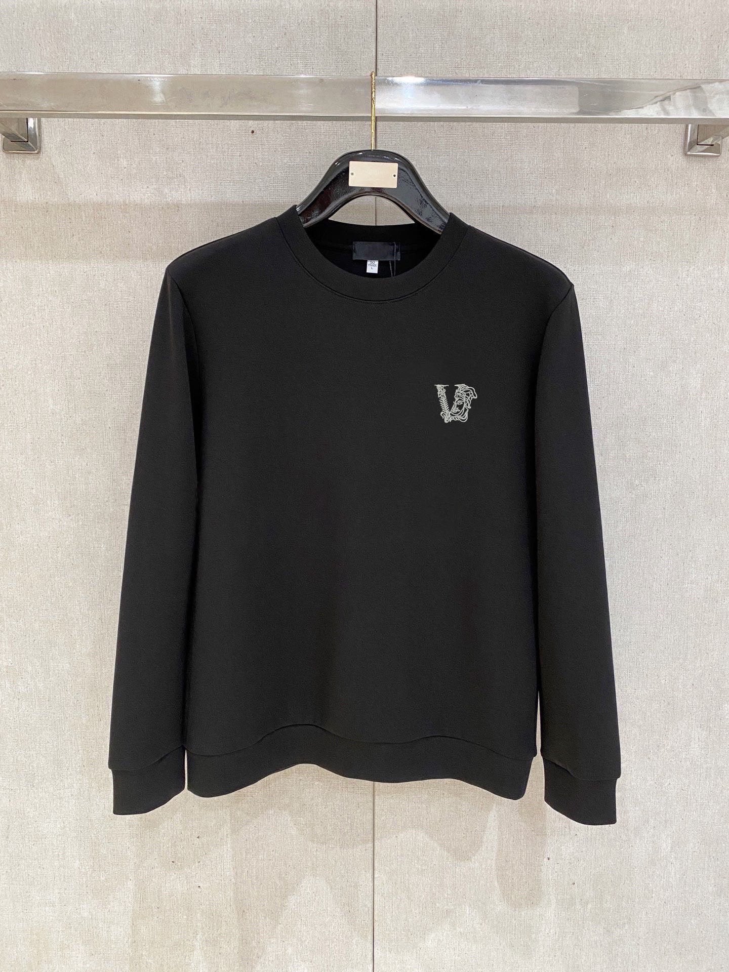 Black crewneck sweatshirt with small V logo on left chest