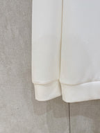 White sweatshirt fabric close-up showing cuff and rounded hem