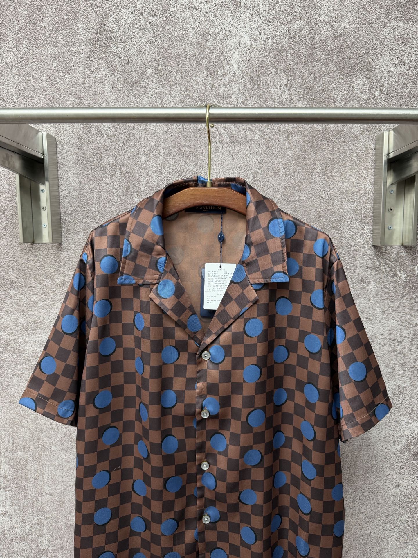 Brown short-sleeve button-up shirt with blue dot checker print and pointed collar