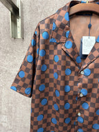Brown short-sleeve shirt with blue checker pattern and scattered blue circle dots