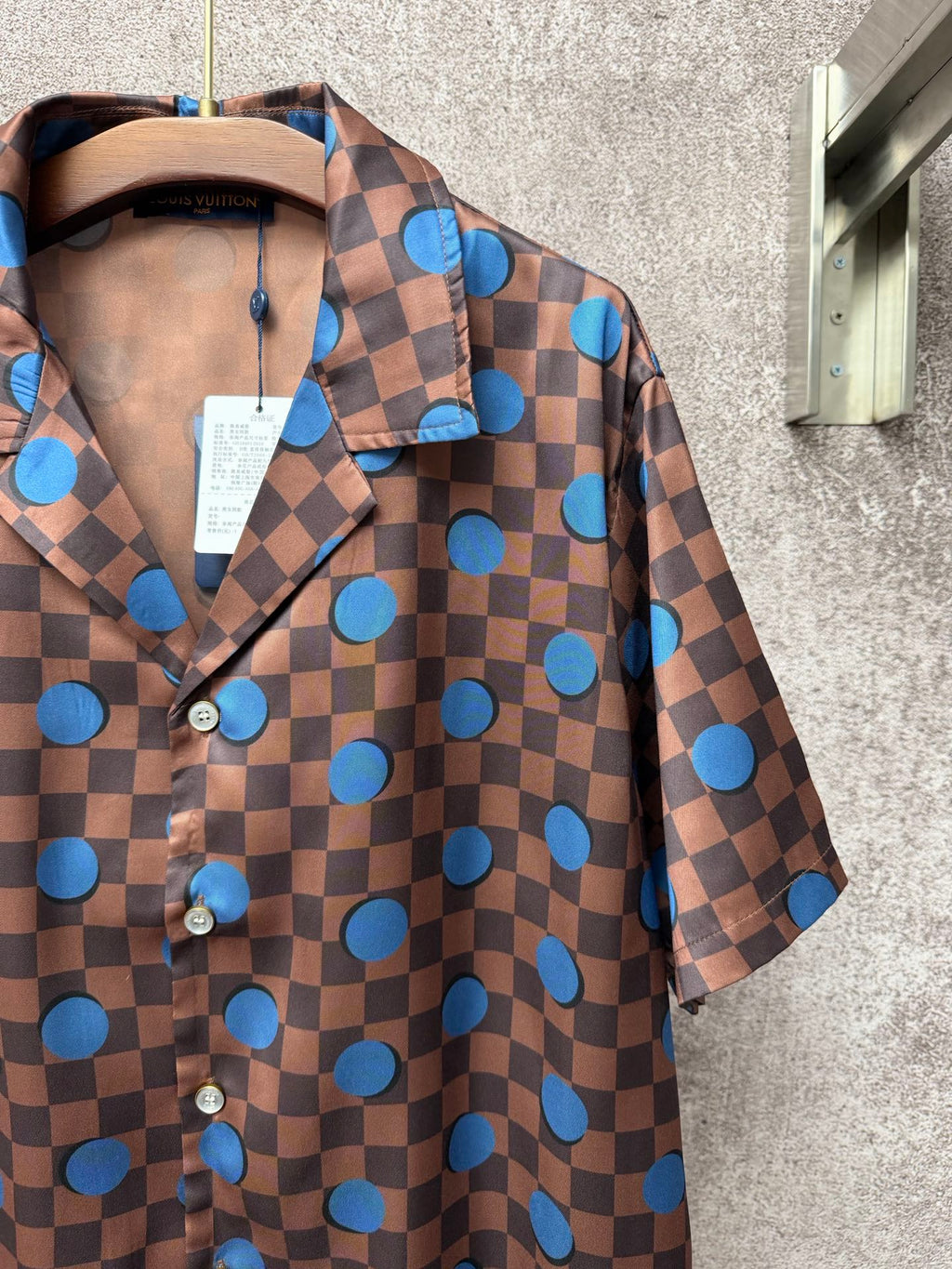 Brown short-sleeve shirt with blue dot check print, button placket, and fold-over collar