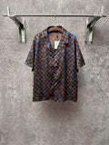 Brown short-sleeve shirt with blue checker pattern and large circular motifs