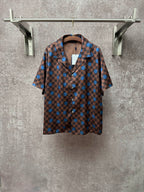 Brown short-sleeve shirt with blue checker pattern and large circular motifs