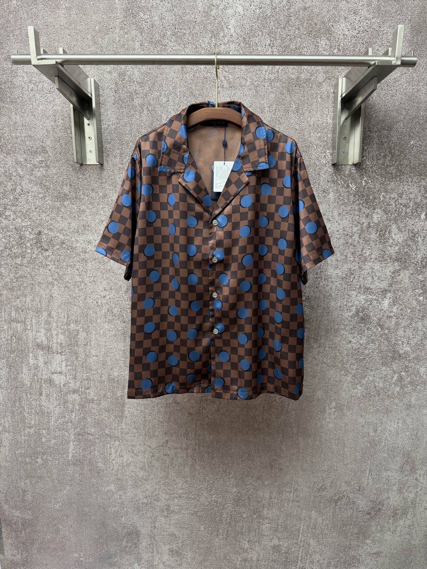 Brown short-sleeve shirt with blue checker pattern and large circular motifs