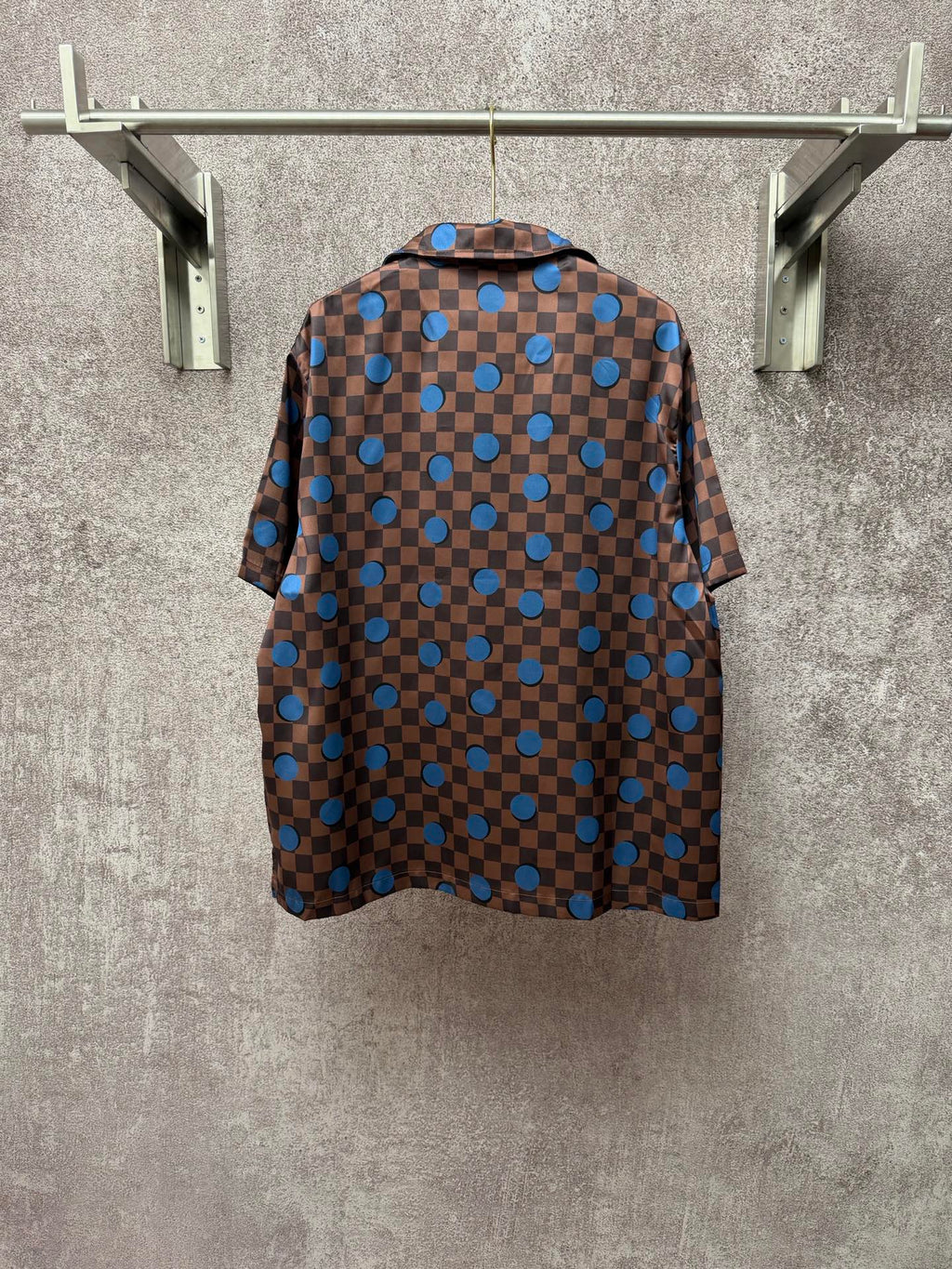 Brown short-sleeve shirt back with blue checker squares and circular dot pattern
