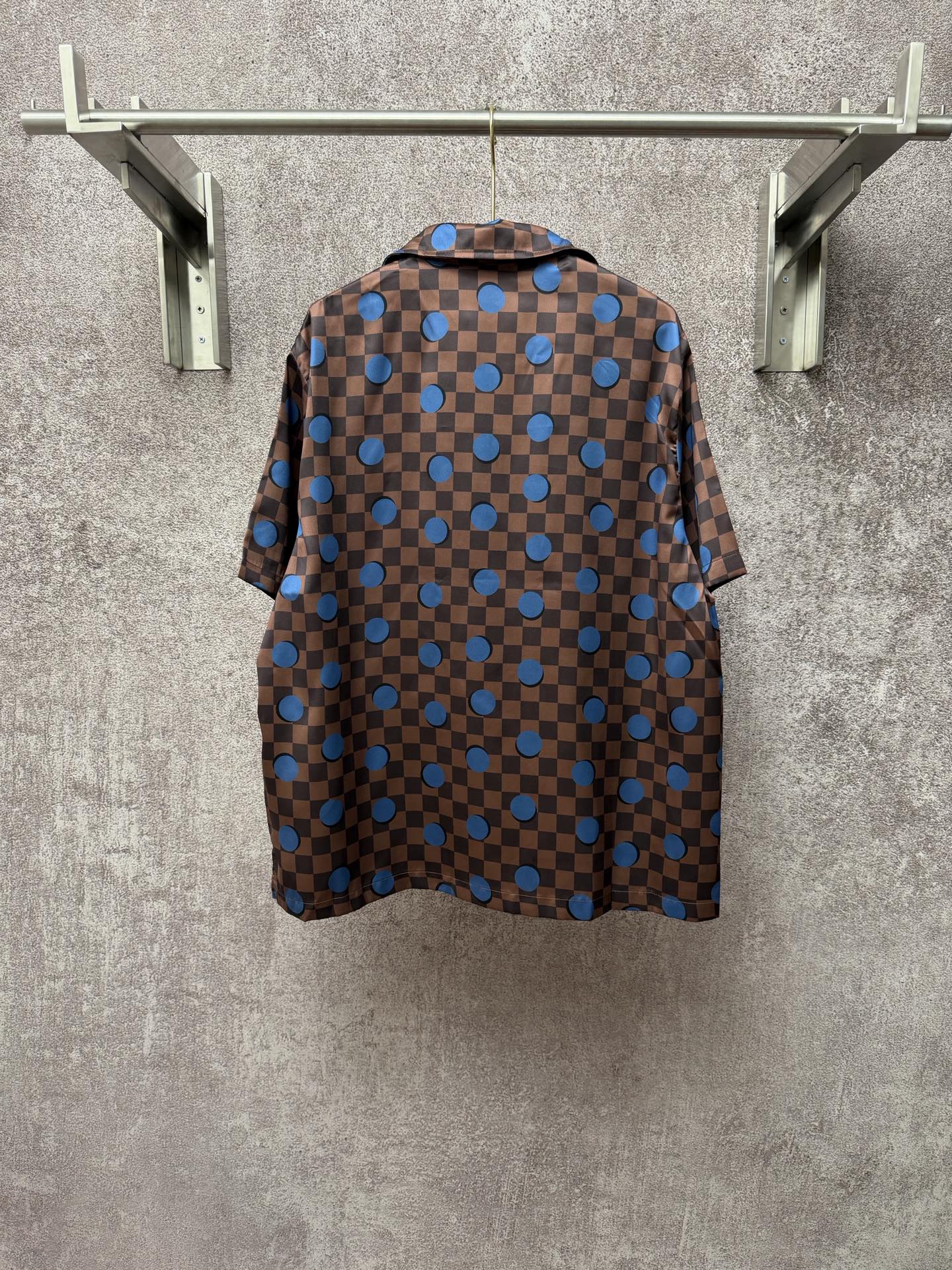 Brown short-sleeve shirt back with blue checker squares and circular dot pattern