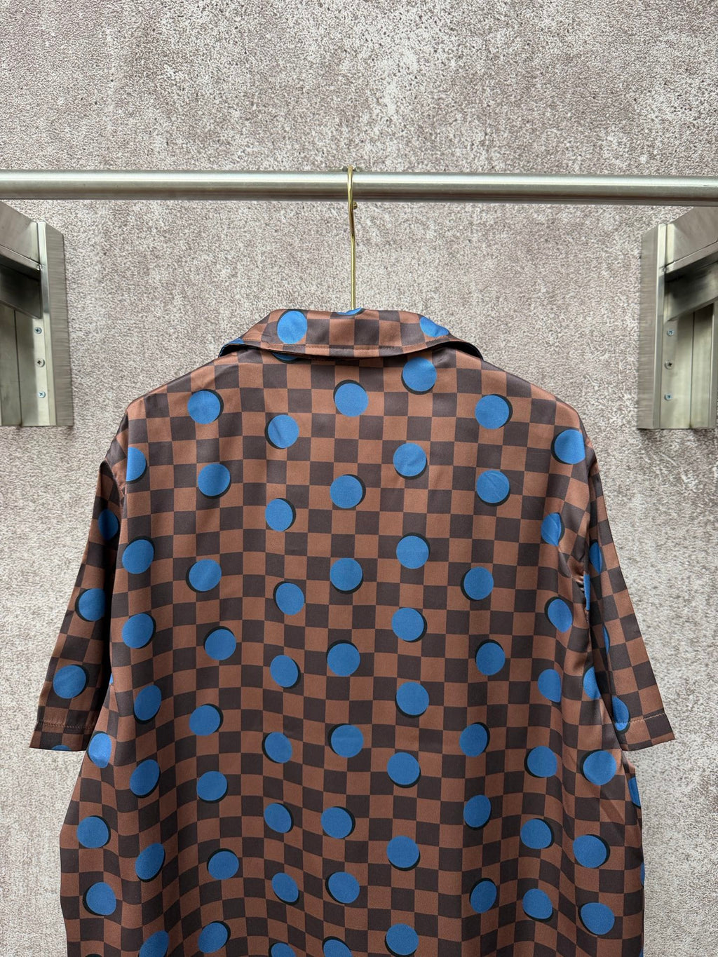 Brown short-sleeve shirt back with blue checker squares and round blue circle motifs