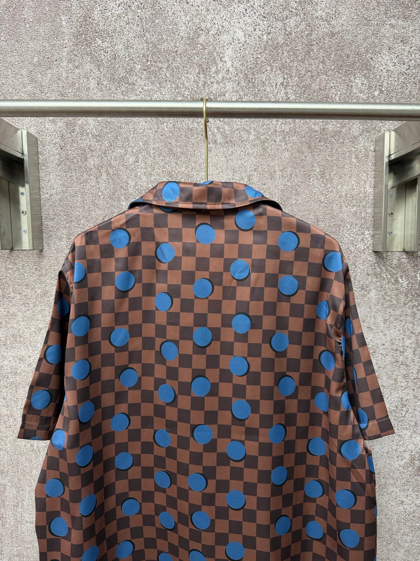 Brown short-sleeve shirt back with blue checker squares and round blue circle motifs