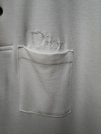 White polo shirt fabric close-up with embroidered chest logo and pocket
