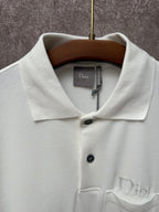 White Dior polo shirt close-up on collar, buttons, and embroidered chest logo