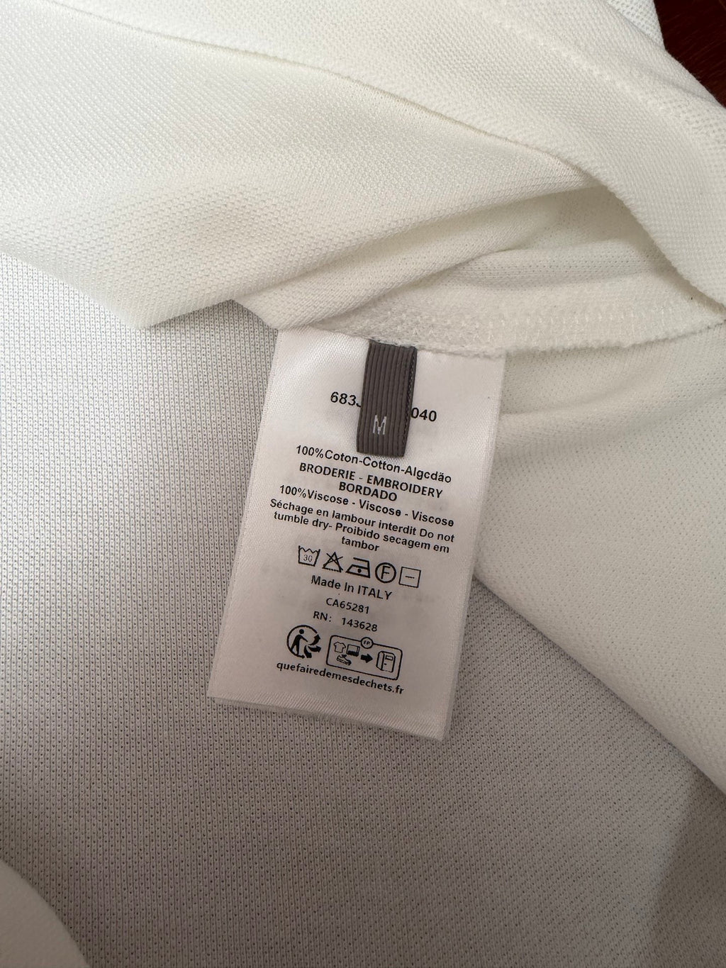 White polo shirt care label close-up with cotton and viscose fabric details