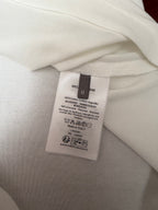 White polo shirt care label close-up with cotton and viscose fabric details