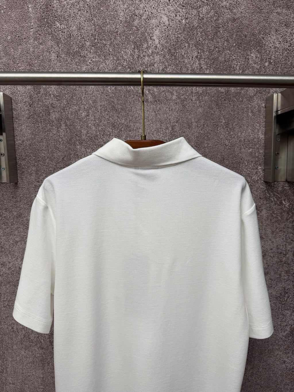 White Dior polo shirt back view on hanger with short sleeves and ribbed collar