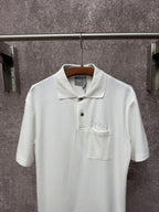 White Dior polo shirt front view with folded collar, buttons, and embroidered logo