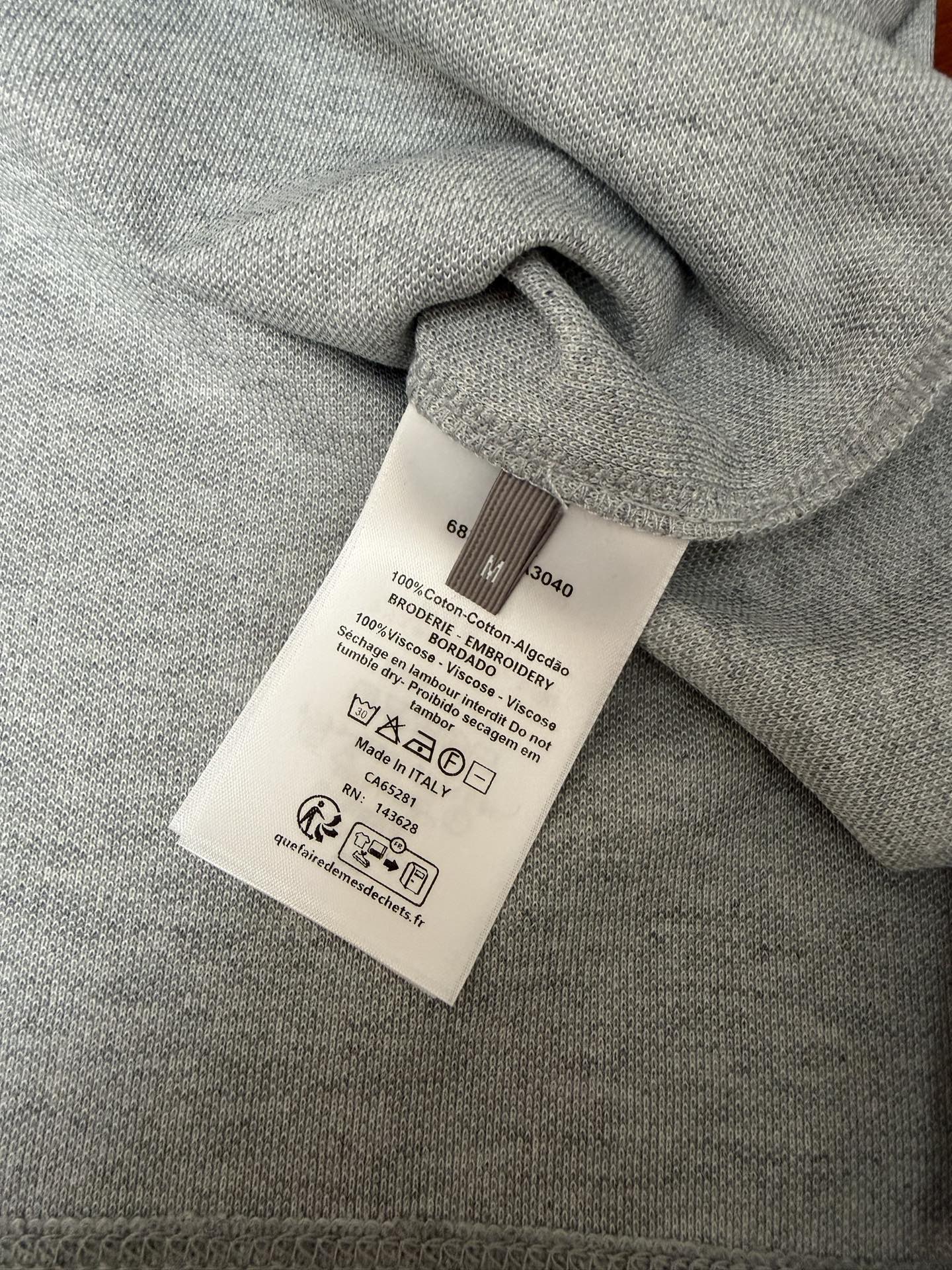 Care label on light gray Dior short-sleeve polo knit