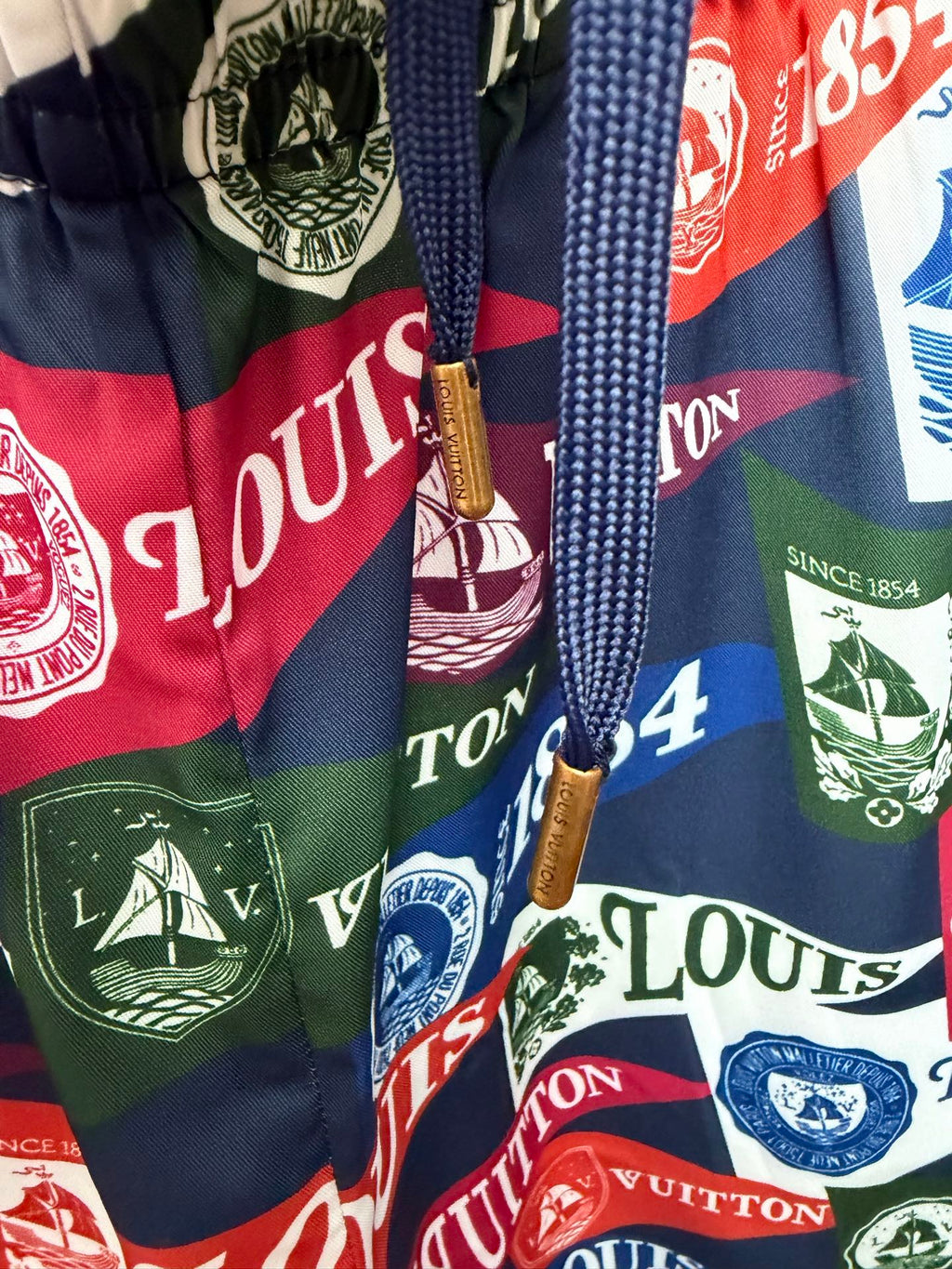 Drawstring shorts with multicolor Louis Vuitton-style logo print and tassel