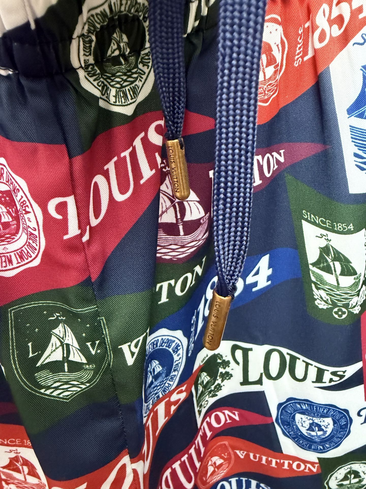 Drawstring shorts with multicolor Louis Vuitton-style logo print and tassel