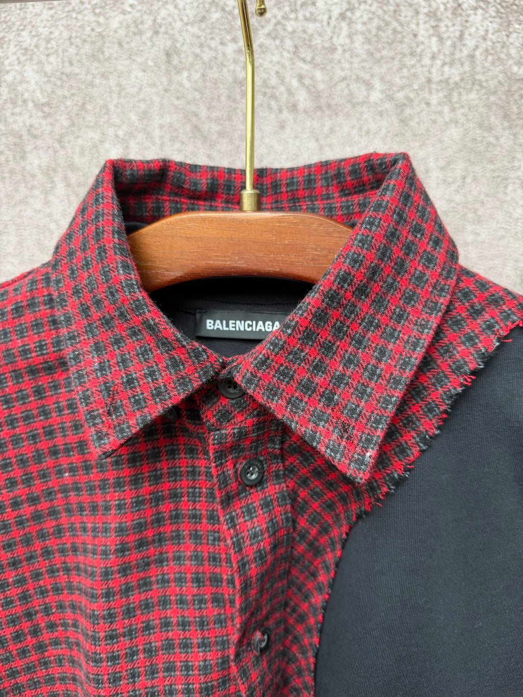 Long shirt collar detail with red-and-black check fabric and black neck label