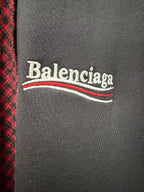 Balenciaga logo on dark gray chest panel of a red-and-black check shirt