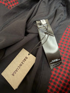 Balenciaga clothing tags attached to dark gray fabric with red plaid lining