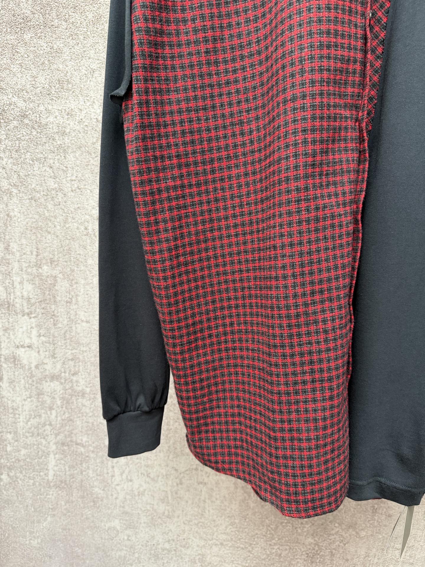 Long shirt fabric detail with red-and-black check pattern and dark gray sleeves