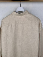 Beige long-sleeve button-up shirt back panel with center seam stitching