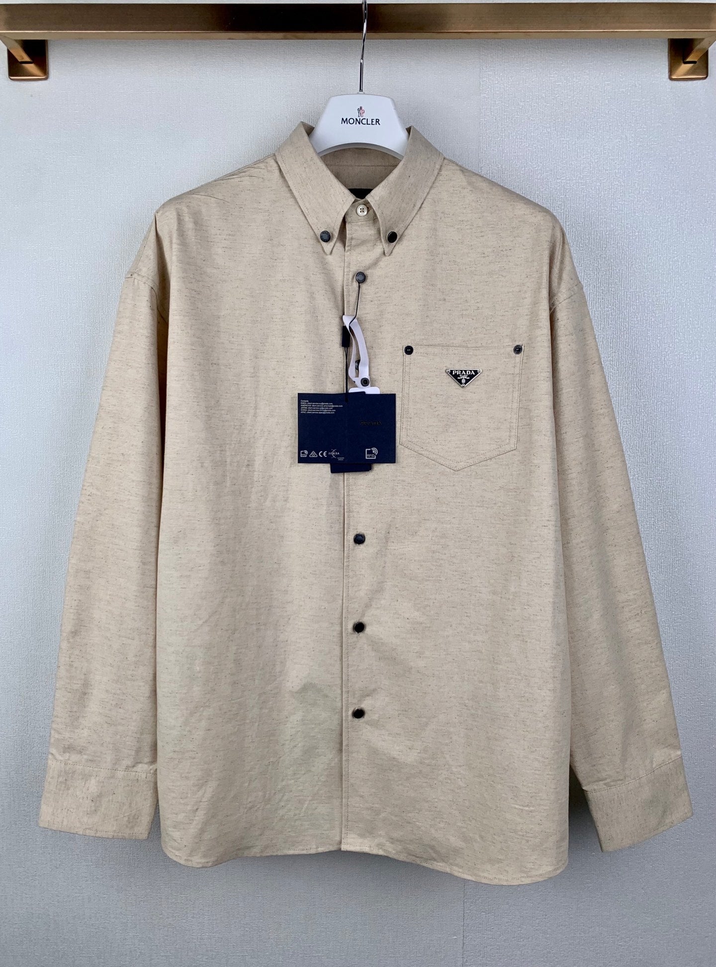 Beige long-sleeve button-up shirt with point collar and chest pocket