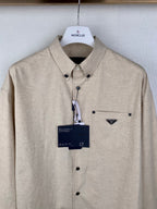 Beige long-sleeve button-up shirt with point collar, chest pocket, hanging tag