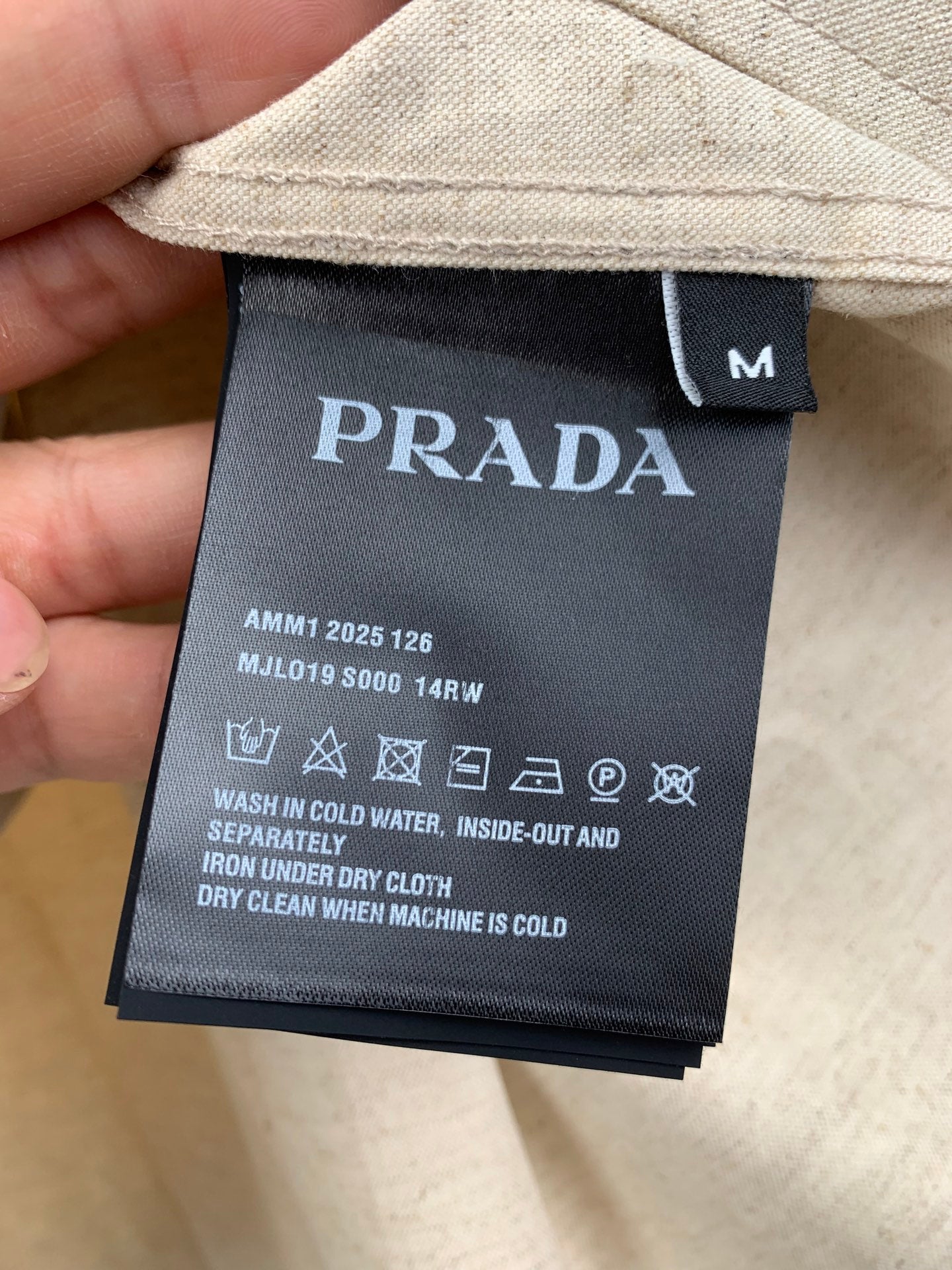 Beige shirt inside neck label with PRADA logo and care information